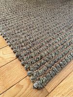 Close-up of rug corner showing loop pile weave and bound edge