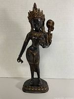 full view of bronze deity statue on pedestal base