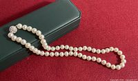 Full view of knotted cultured pearl necklace with clasp