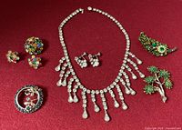All eight jewelry pieces displayed on red background