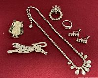Front view of all seven jewelry pieces on red background