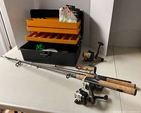 Open tackle box with trays, two fishing rod-reel combos displayed
