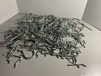 Pile of mixed metal pegboard hooks