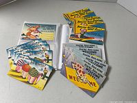 Album open with loose stacks of colorful humorous postcards