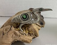 Side view of sterling silver heron with abalone wing and eye inlays on driftwood base