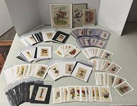 Overview of numerous sleeved cigarette silks spread on table