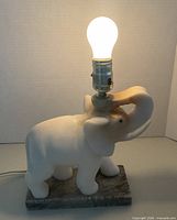 Full view lit showing marble elephant lamp with bulb
