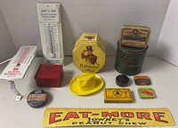 Overall view of lot showing thermometers, Billmore items, tins and ruler