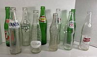 Group of ten vintage soda bottles front view