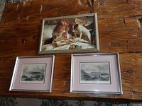 All three framed prints displayed on wooden surface
