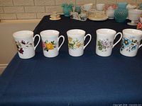 Front view of five floral bone china mugs