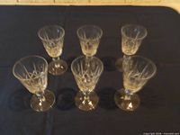 Six cut crystal stemmed glasses arranged on table