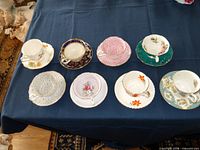 All eight cup and saucer sets displayed on table