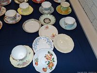 Close-up of several saucers and cups highlighting patterns, colours and gilt trim