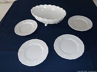 Top view of white pressed-glass fruit bowl and four matching plates