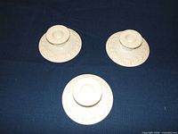 Top view of three white Wedgwood Queensware candlestick holders showing vine relief design