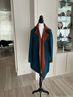 Front view of teal coat on mannequin showing rust lapel