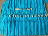 Full felt roll opened showing 12 forks and one fork placed above