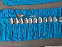 All 12 tablespoons laid in open blue Birks felt roll