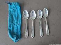 Four sterling silver tablespoons and blue felt bag