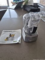 Chopper with work bowl, blade, lid, and manual on countertop