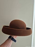 Side profile of brown cloche hat showing rolled brim
