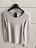 Front view of beige Giorgio Armani crew neck sweater on hanger