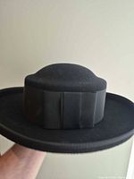 Side profile of hat showing flat crown, wide brim and ribbon band