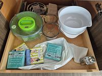 Drawer view of salad spinner, bowls, napkins, shaker
