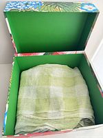 Green and white check scarf folded in decorative box