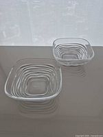 Two clear crystal square bowls side by side showing size and design