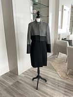 Front view of NISSA black and gray long coat on mannequin