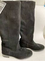 Full side view of both boots showing suede material, knee-high height, block heel, lug sole