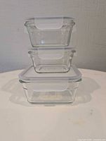 front view, three stacked glass containers with lids attached