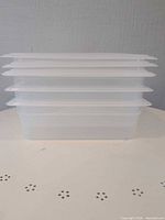 Stacked view of three clear plastic containers showing lids