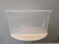 Front view of clear plastic storage bin on stool