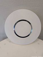 Front view of round white ceiling light with chrome ring