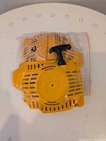 Front view of yellow recoil starter assembly in bag