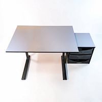 Front angled view showing tilting tabletop, metal legs, attached three drawers
