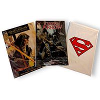 Front view of three DC comic books showing covers and sealed Superman polybag