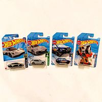 All four Hot Wheels cars in original packaging displayed side-by-side