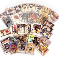 Spread of approximately 48 mixed hockey trading cards showing rookies, patch/jersey cards, and redemption card from various sets