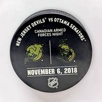 Front of puck showing matchup details, event name and date