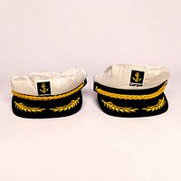 Front view of two captain hats showing anchor patches, gold rope and leaf embroidery