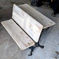 Oblique view showing wood seat, writing surface and cast iron base