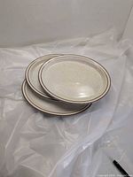 Stack of three oval speckled plates