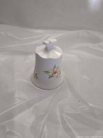 Side view of bone china bell showing floral decal and handle