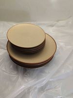 Stack of three sizes of ribbed beige stoneware plates