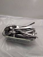 Overall view of flatware piled in Pyrex dish