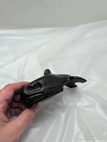 Front and side view of carved stone killer whale